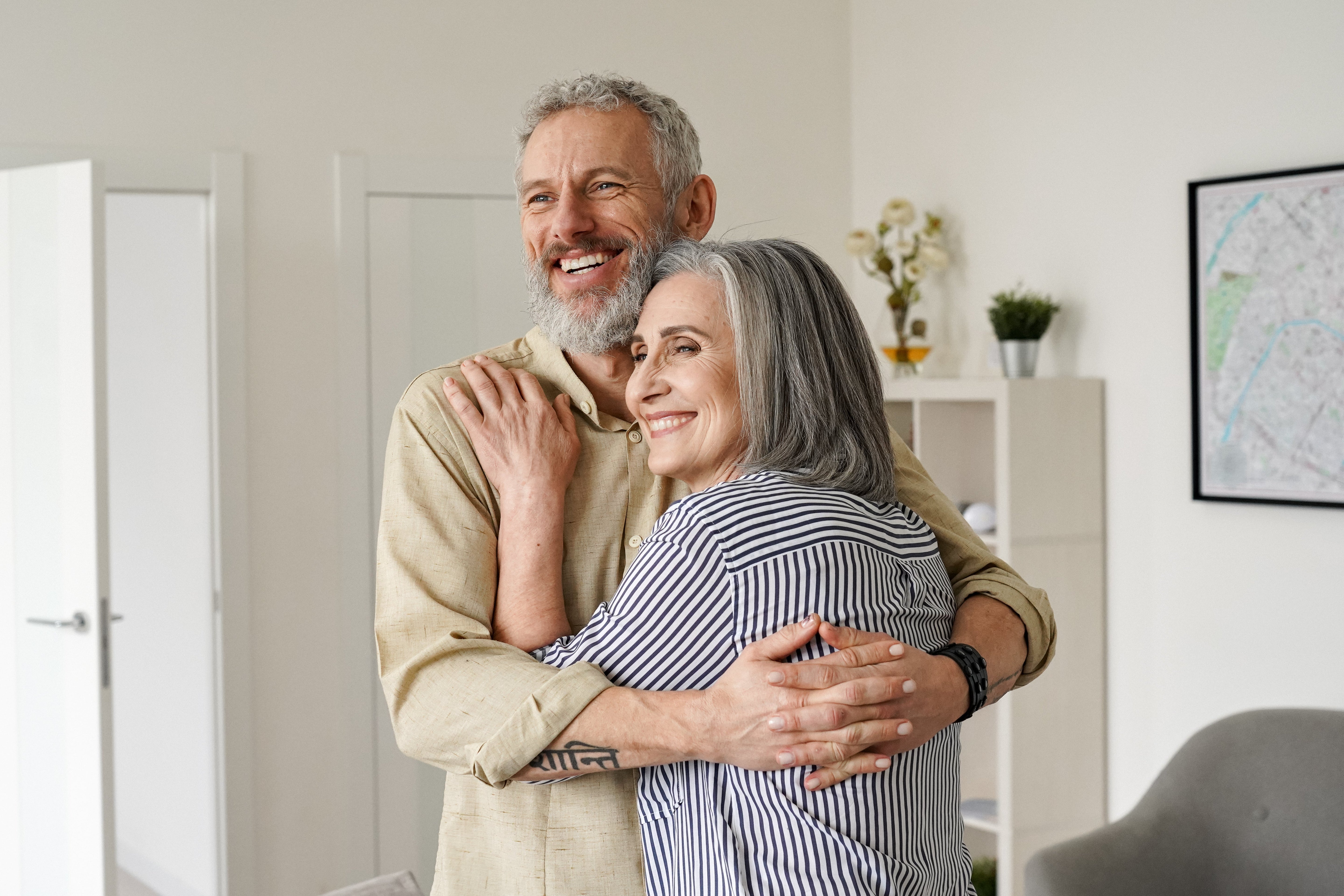 A smiling older couple warmly embracing in their home, symbolizing the peace of mind and clarity that comes from organized estate planning using the OWL Planner.