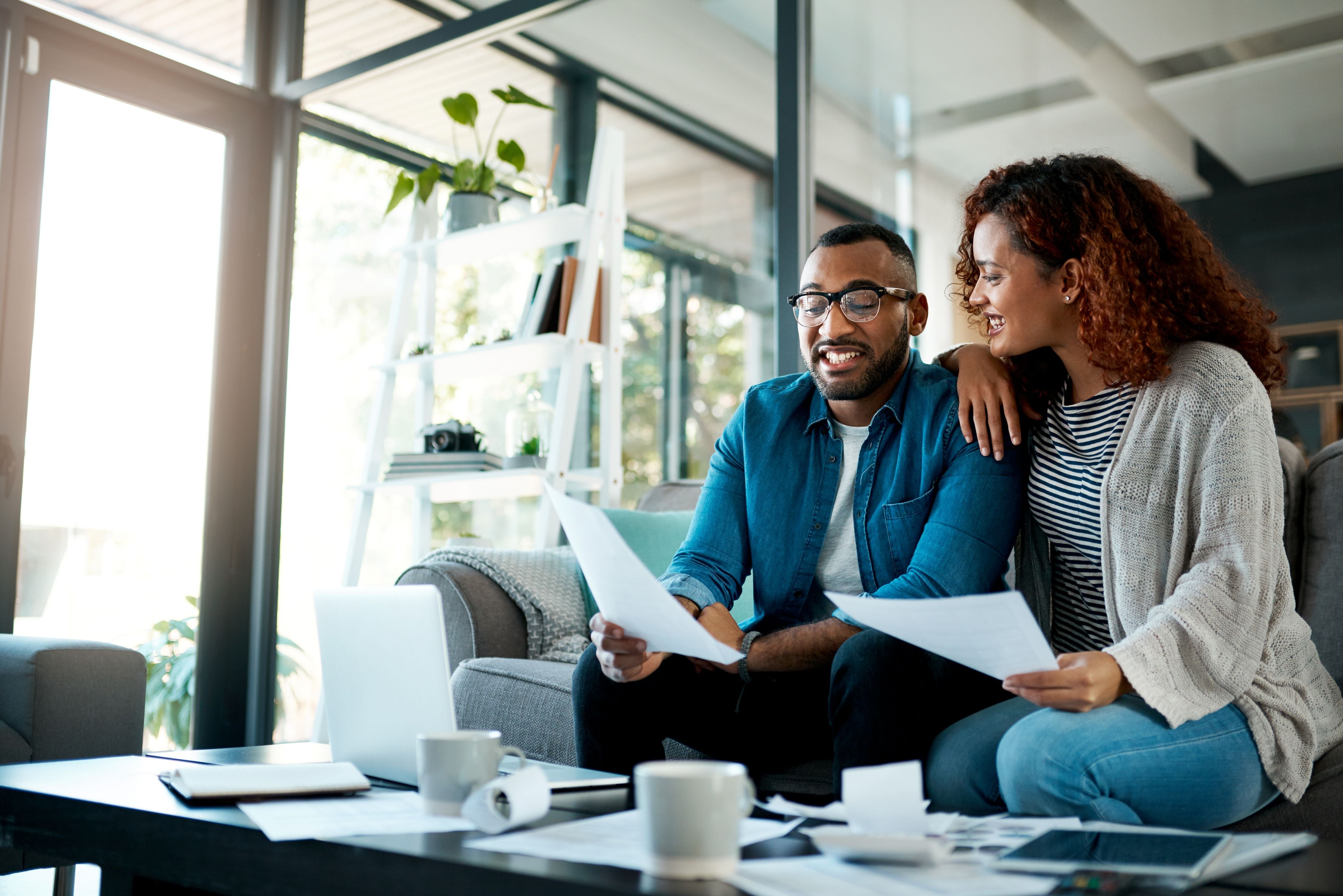 A couple reviewing important estate planning documents at home, representing the value of using an estate planning organizer like the OWL Planner to stay organized and prepared for the future.